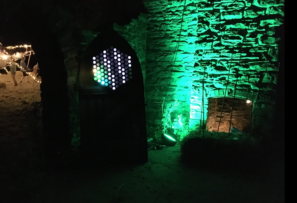 An earlier Tonnetz prototype glowing in a stone archway at a night installation
